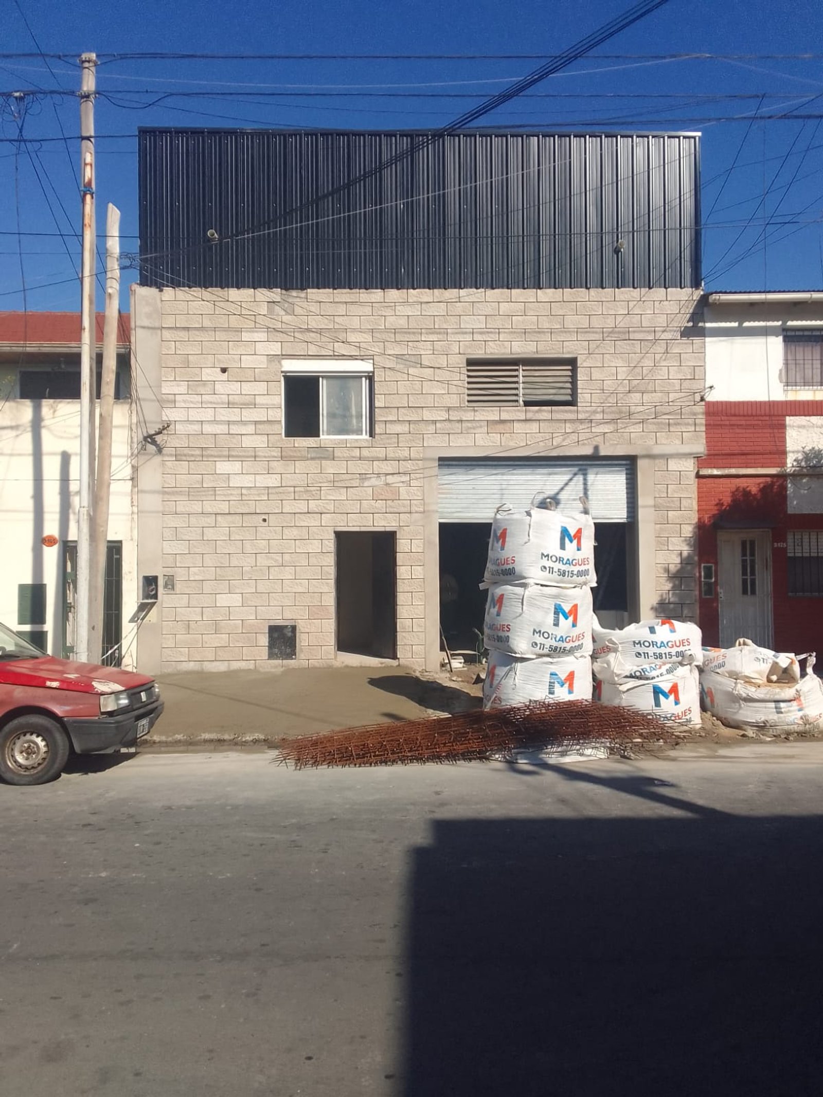 fachada de edificio en construccion con materiales apilados — proyecto Deposito en Avellaneda 3, por Arquitecto Guido Niccoli, en B1872 Sarandí